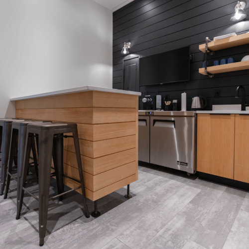 Contemporary staff kitchen with wood and dark accents completed as part of a commercial tenant improvement by Bowline Construction in Langley, BC